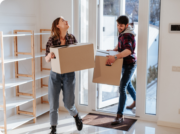 a man and a woman moving boxes into a new home.