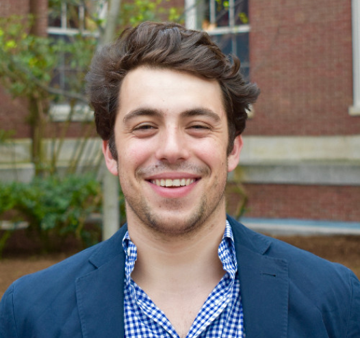 a man in a blue jacket smiles for the camera.