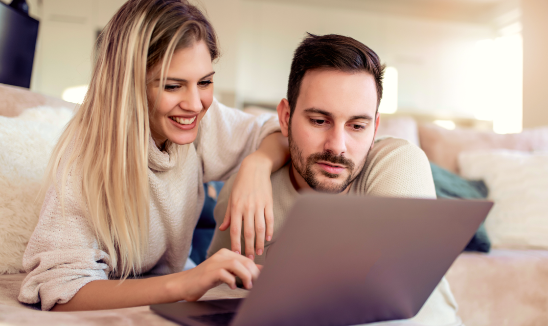 a man and a woman looking at a laptop.